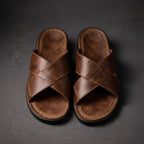 Top-down view of brown crossover strap sandals showing the woven leather-look design