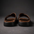 Back view of brown crossover sandals showing the stitched heel edge and stacked black sole