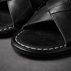 Close-up of the black crossover strap weave with white contrast stitching along the toe opening