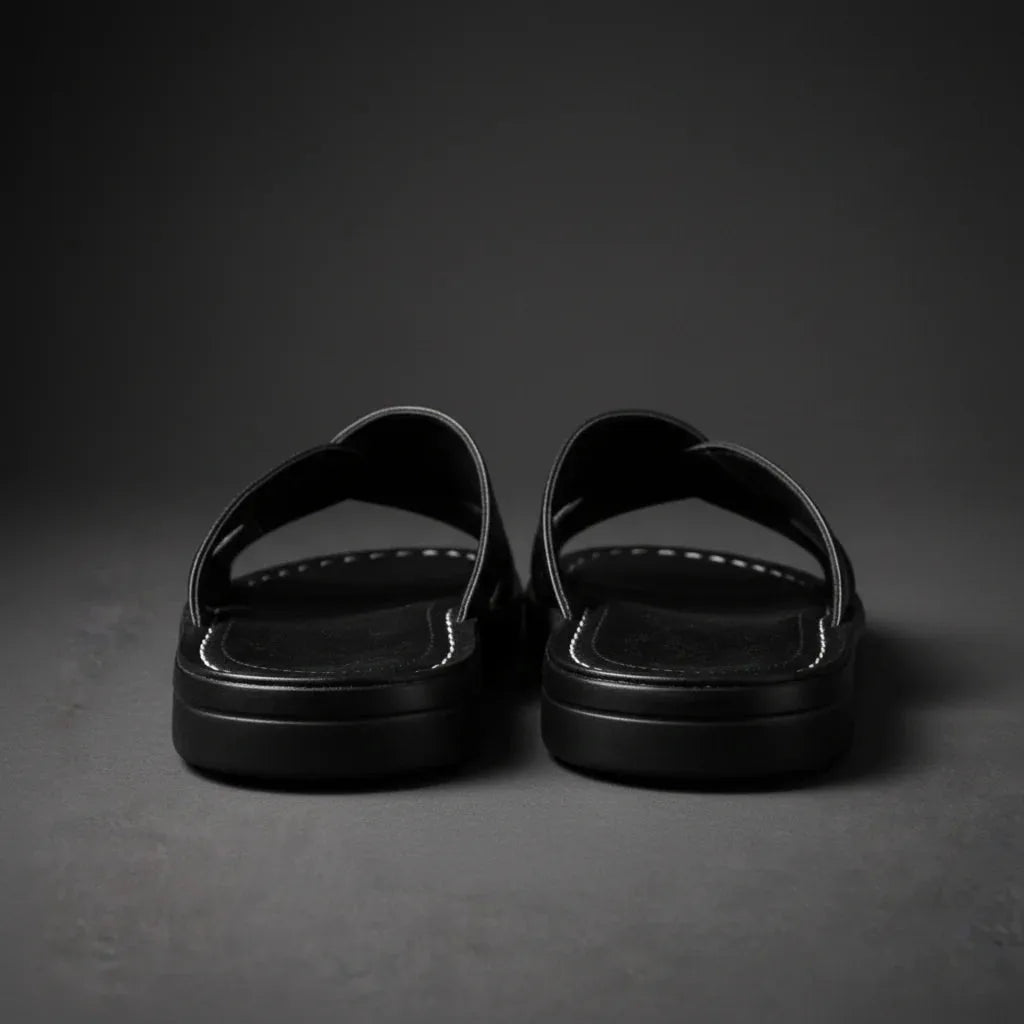 Front corner close-up of black sandals highlighting the round toe shape and ridged sole edge