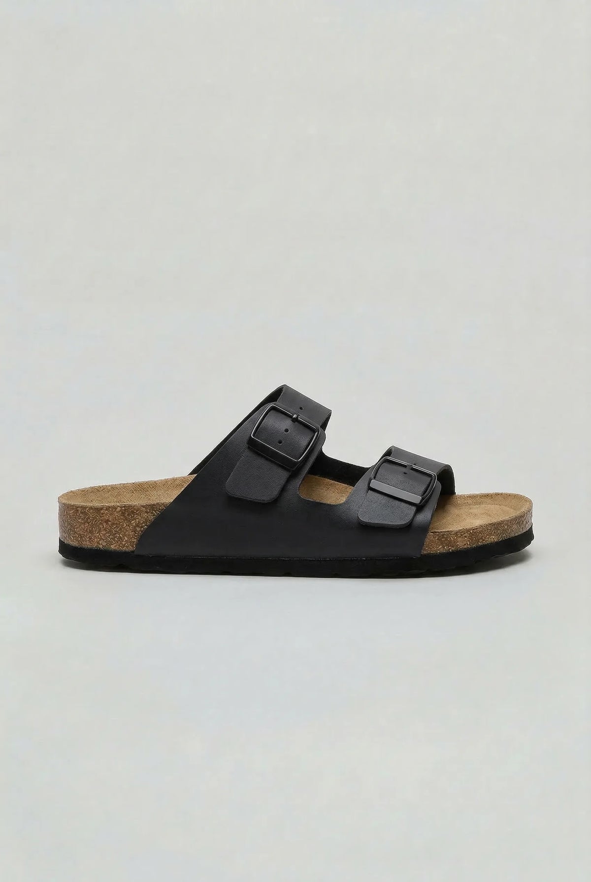 Side profile of a black two-strap buckle sandal with matching black sole and dark hardware