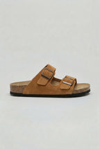 Side view of a rust tan suede two-strap sandal with brown outsole and antique-finish buckles