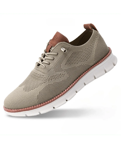 Beige knit sneaker shown at an angle, highlighting the tan leather heel pull tab and white chunky sole