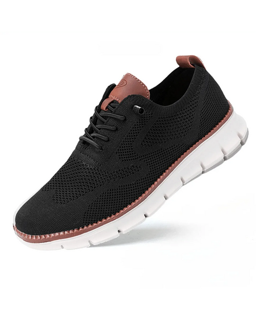 Black knit sneaker with tan leather trim at the heel and lace eyelets, white ridged outsole