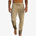 Front view of beige linen-blend pants with drawstring waist and tapered legs with mud-effect gathered ankle cuffs
