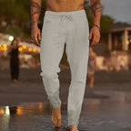Close front view of white linen-blend pants showing elastic drawstring waistband and side hip pocket