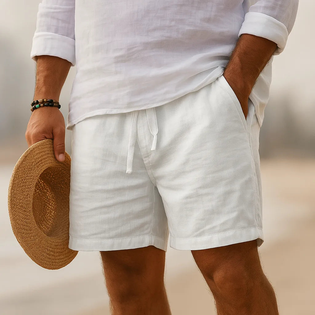 White linen-blend shorts with drawstring waist, styled with a white linen shirt and straw hat