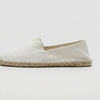 Three-quarter view of white canvas espadrille pair on a plain background
