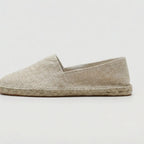 Close-up of jute braided sole stitching along the edge of a canvas espadrille