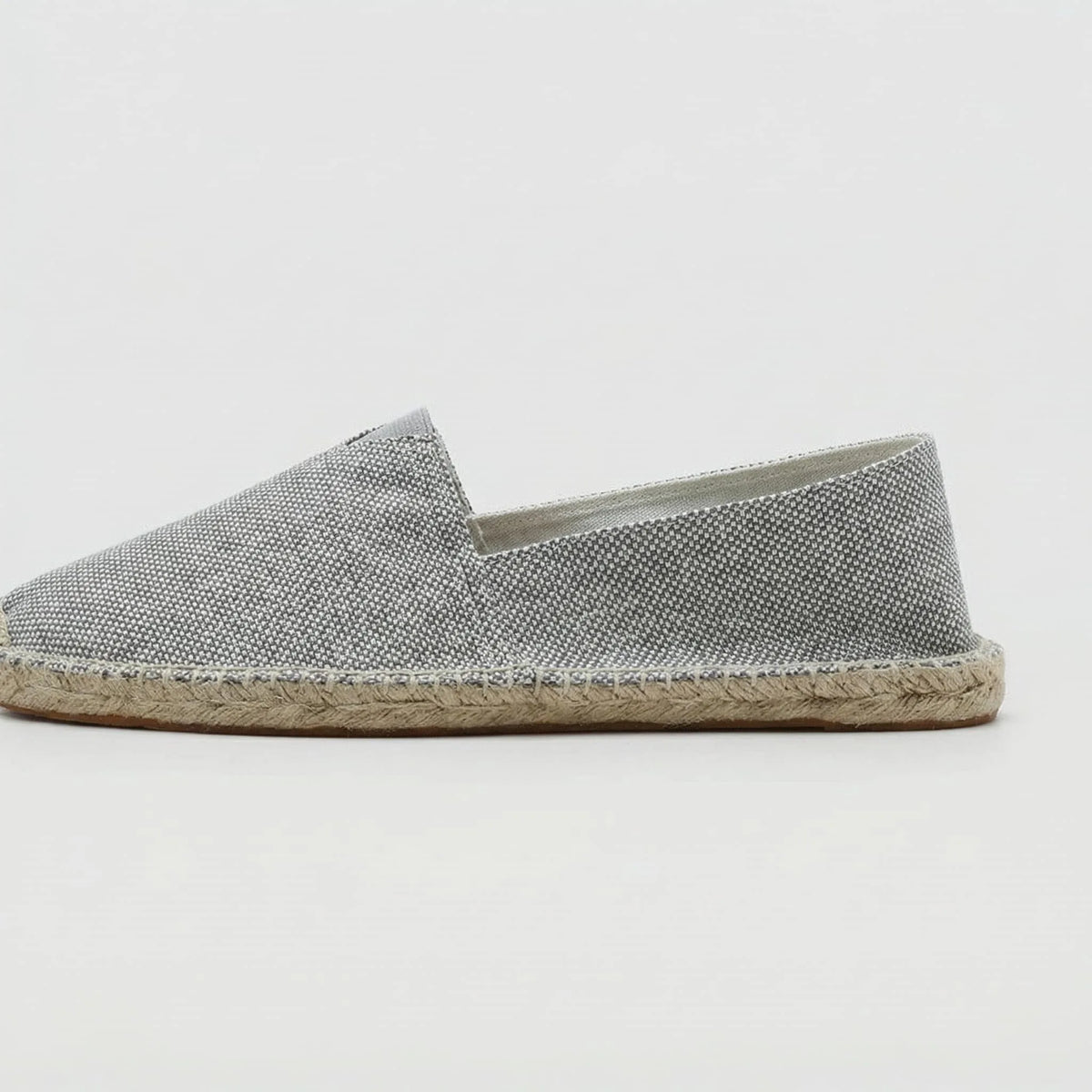 Close-up side profile of grey textured canvas espadrille with braided jute sole edge