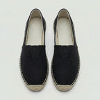 Side profile of black canvas espadrille with contrasting natural jute stitched edge