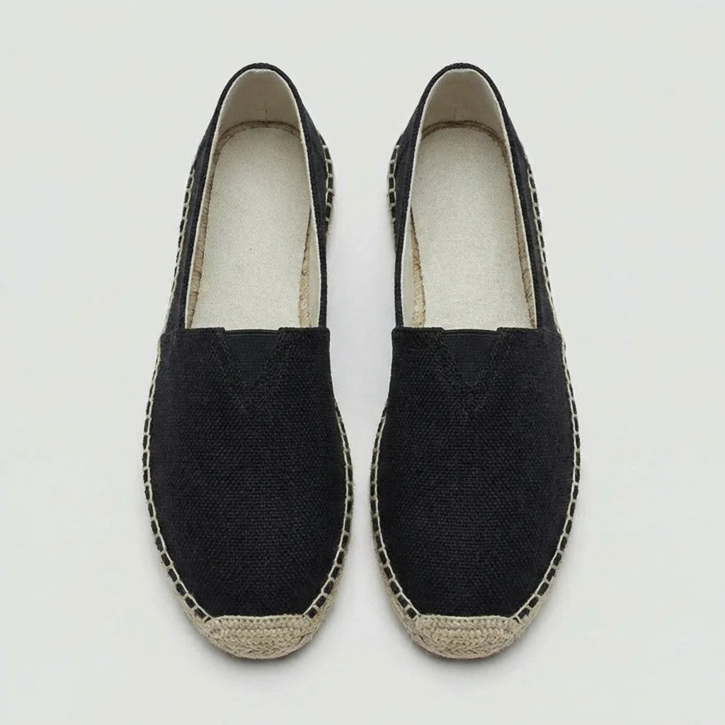 Side profile of black canvas espadrille with contrasting natural jute stitched edge