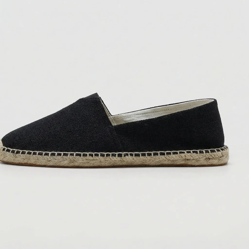 Top-down pair view of black espadrilles showing the V-notch front and jute sole trim