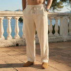 Close-up front view of beige linen drawstring pants with a rope-style tie and tan loafers