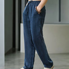 Close-up side view of navy blue linen pants showing fabric texture and hand resting in pocket