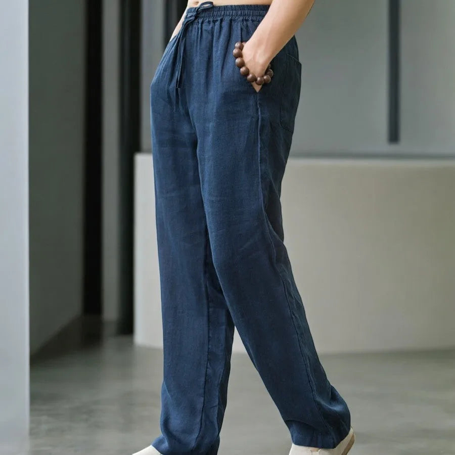 Close-up side view of navy blue linen pants showing fabric texture and hand resting in pocket