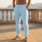 Light blue linen drawstring pants worn with tan loafers, full front-on standing view