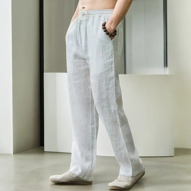 Side view of white linen pants showing drawstring waist and straight leg cut on model