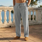 Grey linen drawstring pants shown from the waist with elastic waistband and tan loafers