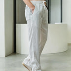 Back and side angle of light grey linen pants highlighting rear pocket and straight hem