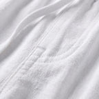 Macro close-up of white linen fabric showing the woven texture and stitched seam detail