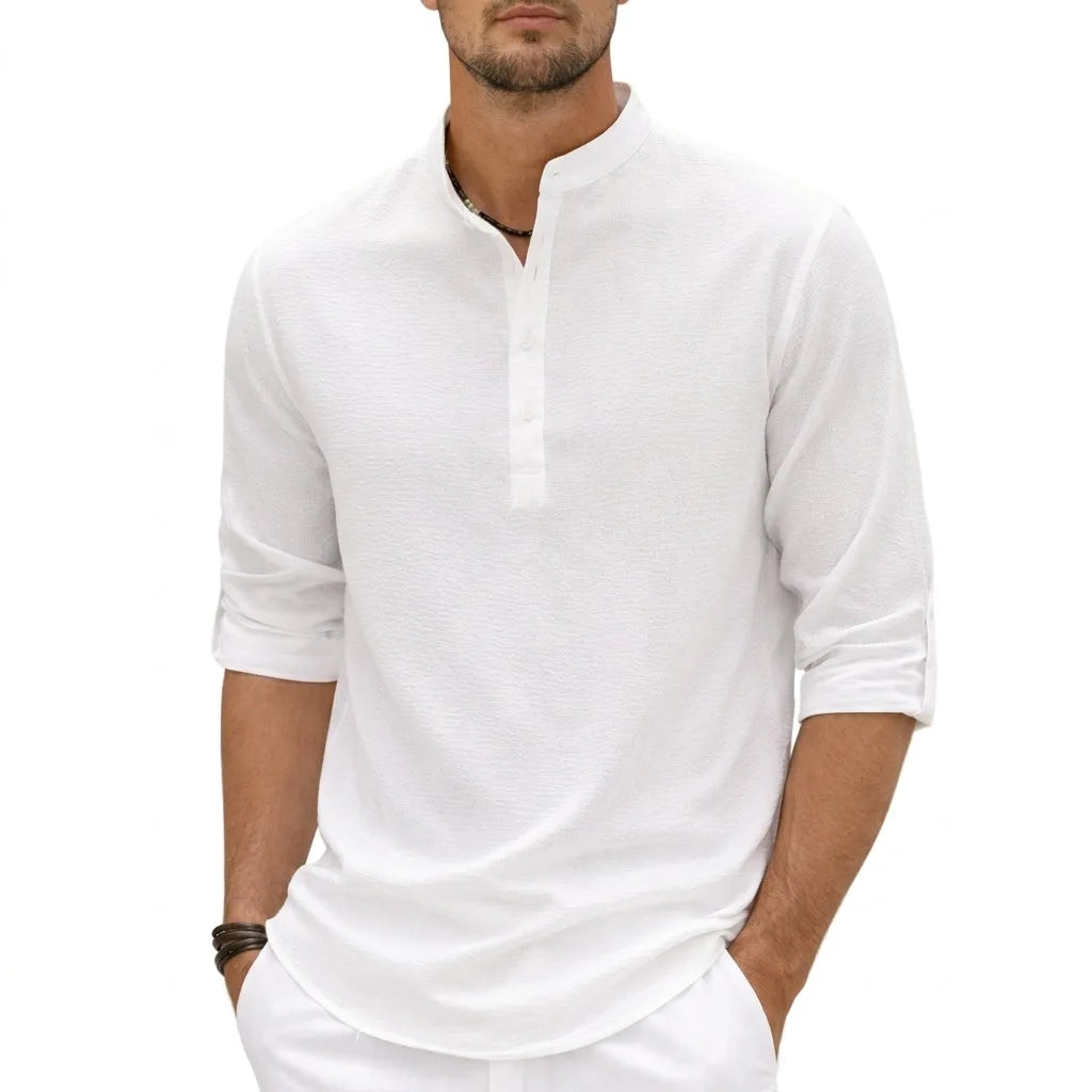 Front view of man wearing a white textured linen-blend grandad collar shirt with half placket buttons, sleeves rolled up