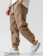 Side view of khaki brown linen jogger trousers showing tapered elastic ankle cuff and relaxed wide leg