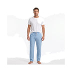 Man wearing light blue linen trousers with a white t-shirt, styled barefoot for a casual look
