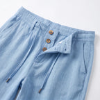 Close-up of the waistband showing wooden buttons, belt loop and drawstring detail with toggle ends