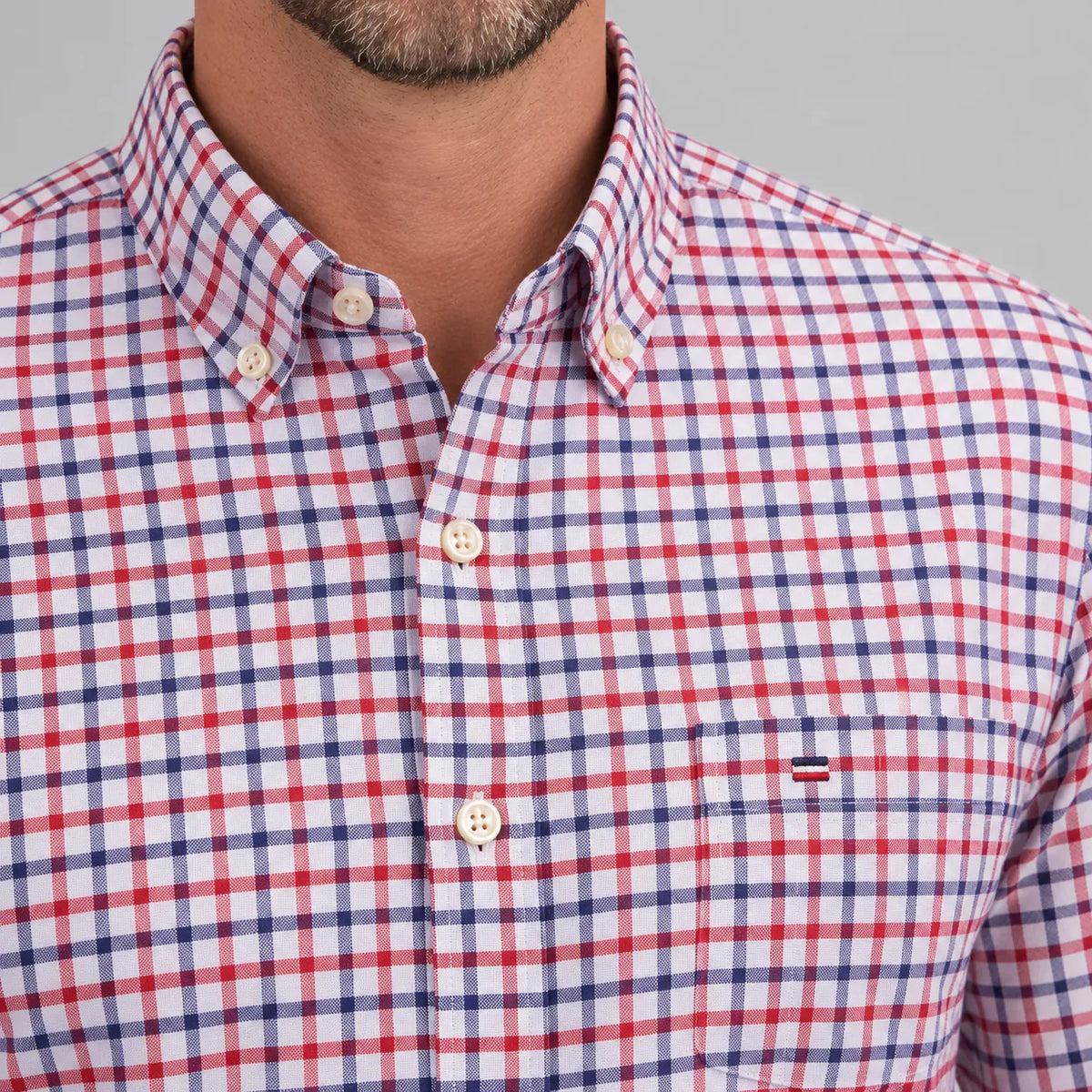 Close-up of the button-down collar and chest pocket detail with contrast flag emblem