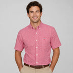 Front view of a man wearing a red and white gingham check short-sleeve shirt with chest pocket