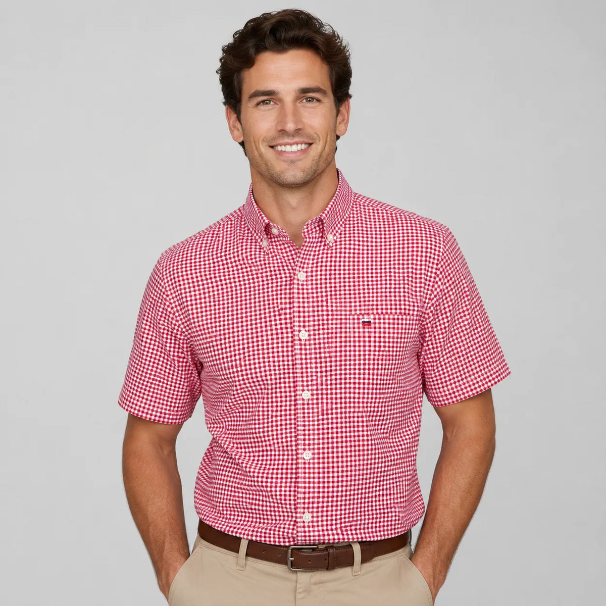 Front view of a man wearing a red and white gingham check short-sleeve shirt with chest pocket