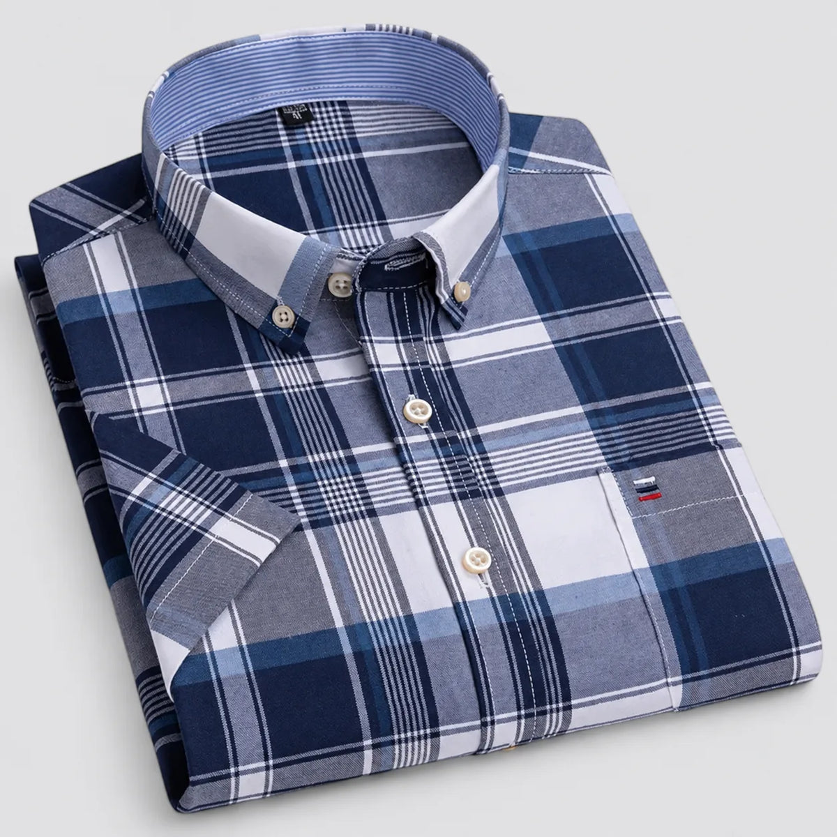 Folded navy and blue plaid shirt highlighting the bold check pattern and contrast collar stand