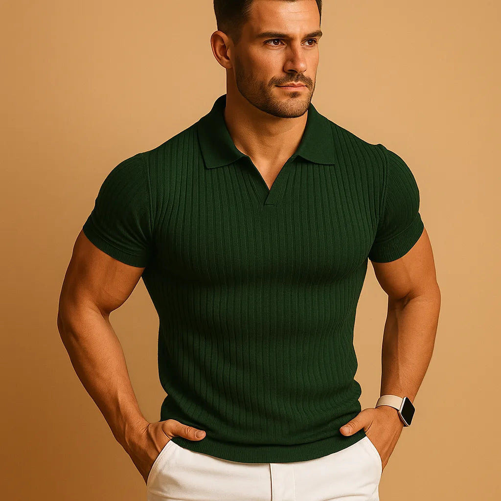 Man wearing a dark green ribbed knit polo with open collar, short sleeves and a smart watch, white trousers below