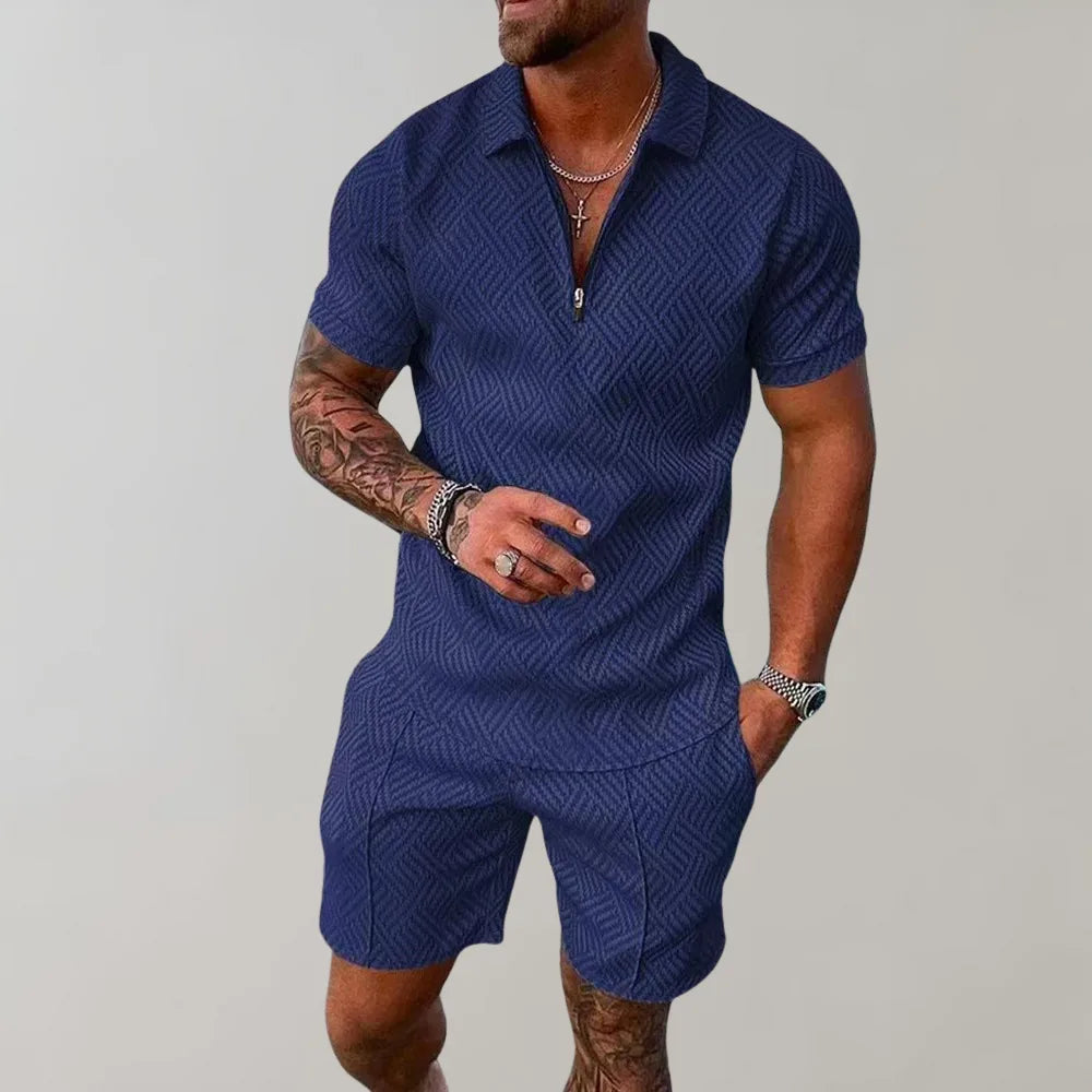 Man wearing a navy blue textured polo and matching shorts set with half-zip collar, hand in pocket