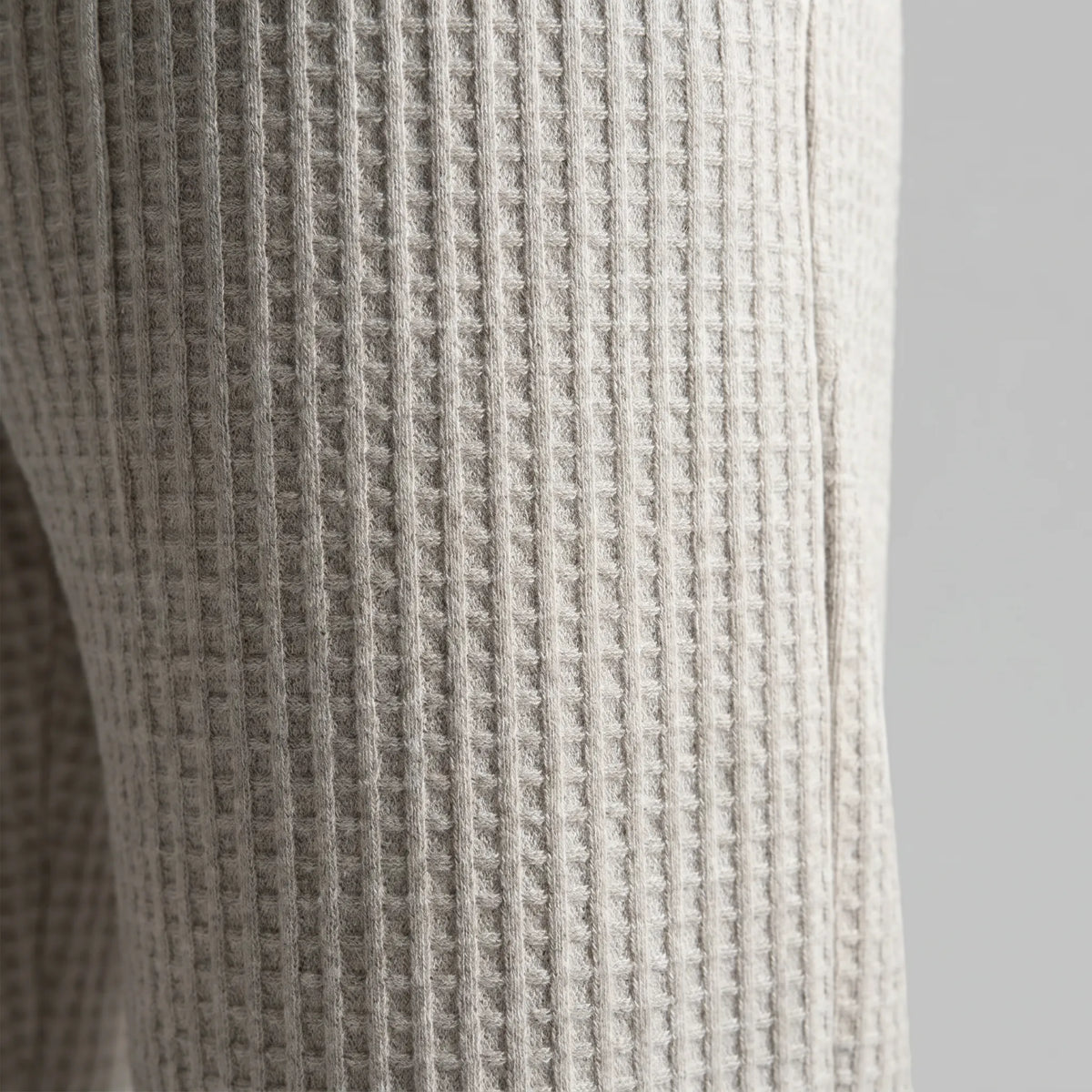 Macro shot showing the waffle knit texture and side seam of the grey fabric