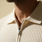 Close-up of a man's hand in the pocket of grey knit shorts showing fabric texture