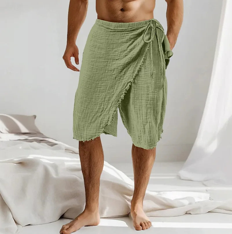 Sage green cotton gauze wrap sarong shown front on, with a tied waist bow and raw frayed hem detail.
