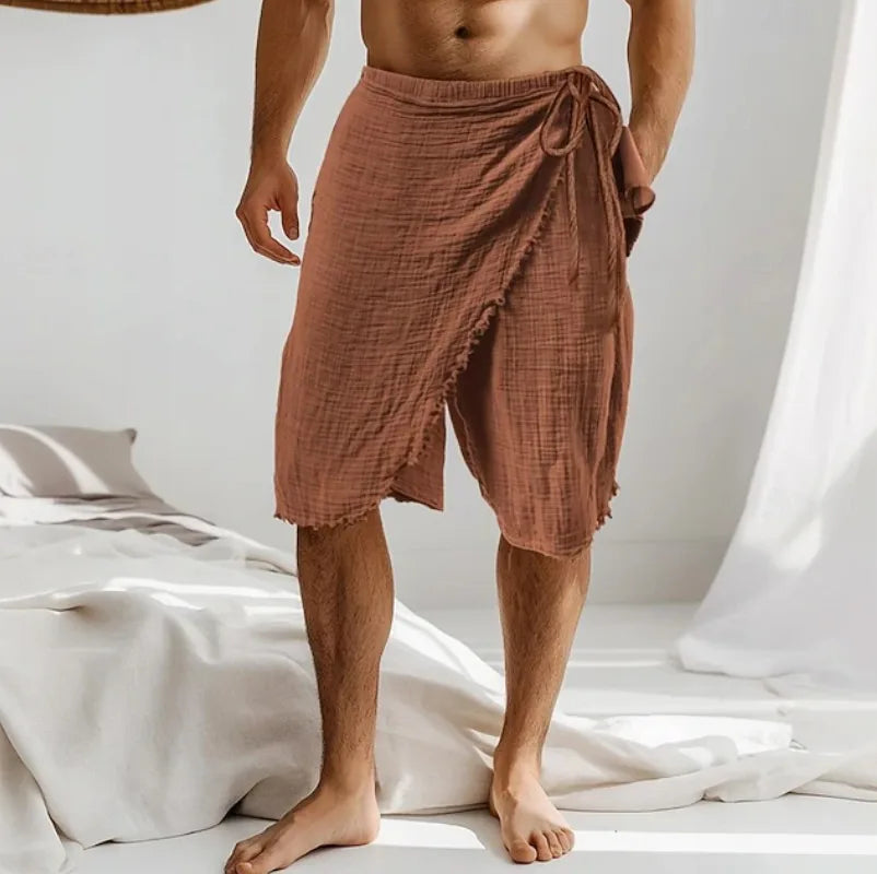 Rust brown wrap sarong tied at the hip, close-up of the crinkled cotton weave and knotted side tie.