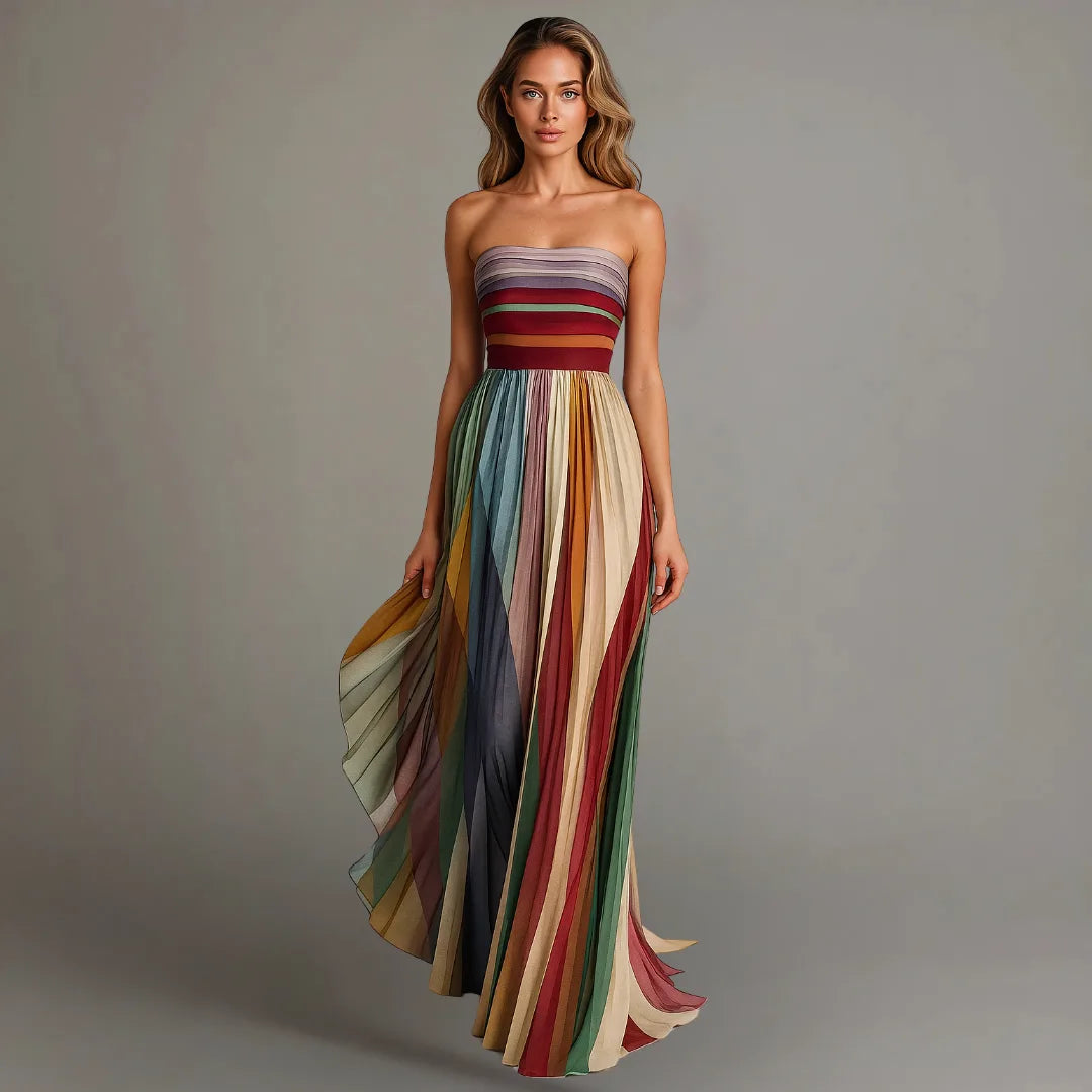 Woman in a strapless multicolour pleated maxi dress standing front on, showing the floor-length A-line silhouette.