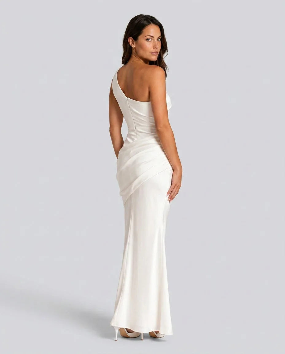 Back view of ivory white one-shoulder maxi dress showing low back line and gathered waist drape