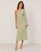 Front view of model wearing a sage green one-shoulder maxi dress with long bell sleeve and ruched waist detail