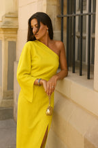 Close-up side view of the yellow one-shoulder dress highlighting the draped shoulder and relaxed bell sleeve