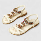 Close-up side view of black sandals highlighting the beaded strap and flexible flat sole