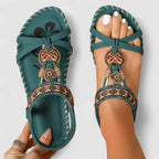 Top view of teal sandals featuring crossover straps, beaded trim and floral-print footbed
