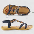 Side and sole view of navy sandals showing beaded T-strap, elastic heel strap and tan footbed
