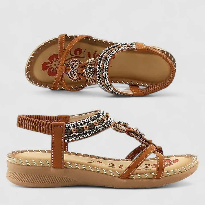 Side profile of black beaded sandals worn on a model's foot, showing elastic ankle strap