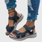 Model wearing beige sandals while walking, side profile capturing full platform sole height
