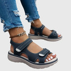 Black sandal shown from behind, revealing open heel cut-out and contoured ankle strap