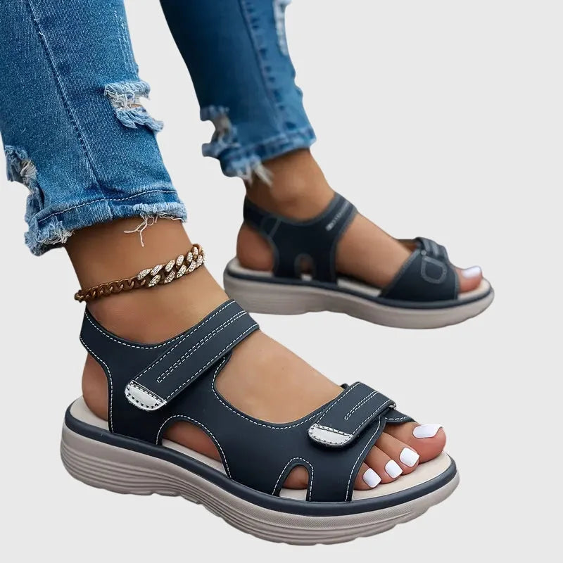 Black sandal shown from behind, revealing open heel cut-out and contoured ankle strap